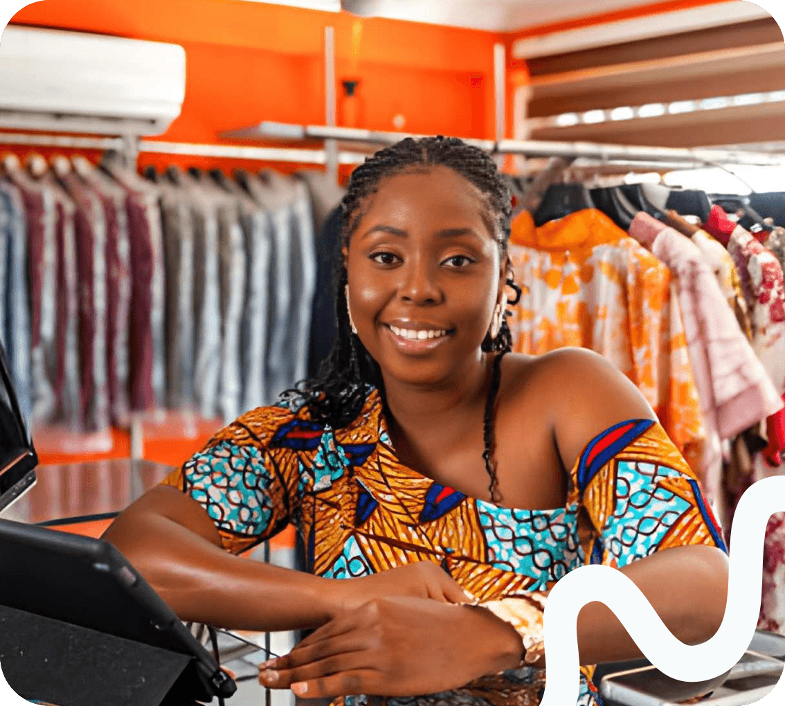 A shop owner at the counter of a clothing store
